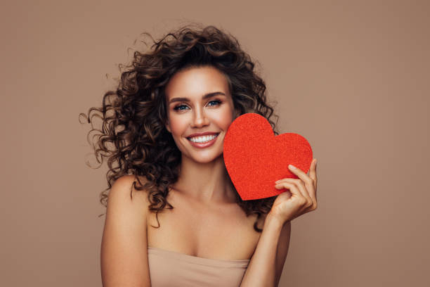 Beautiful woman holding an artificial heart stock photo