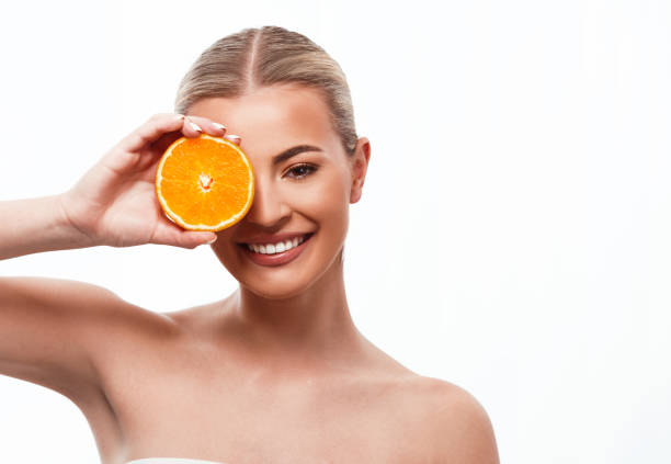 Beautiful woman holding an orange stock photo