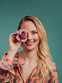 istock Beautiful woman holding rose infront of face 1147606110