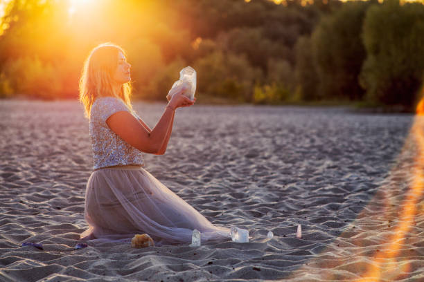 Beautiful woman on beach holding healing crystals Woman is doing crystal healing on beach, magic hour. healing crystals stock pictures, royalty-free photos & images