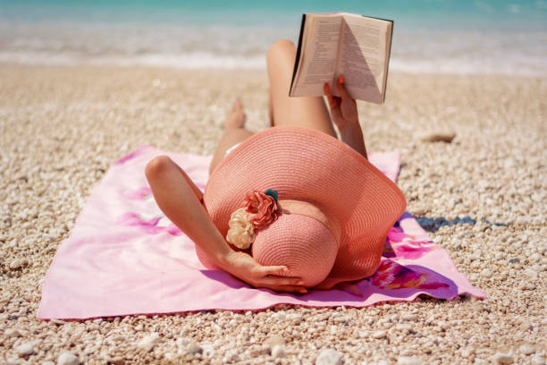 Beautiful woman reading on beach stock photo