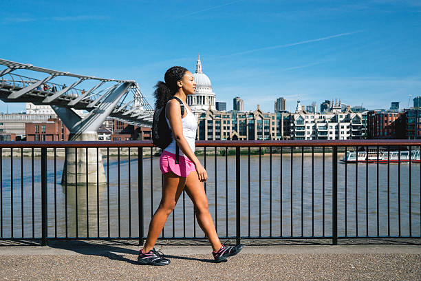beautiful woman running in city street - south bank london stockfoto's en -beelden