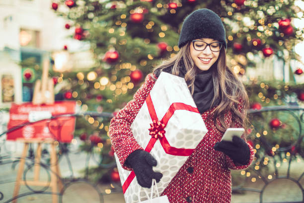beautiful woman shopping in the city - smartphone christmas imagens e fotografias de stock
