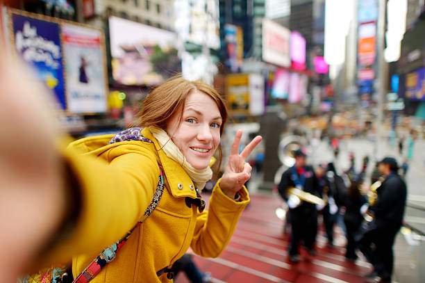 wanita cantik mengambil selfie di times square - traveler new york potret stok, foto, & gambar bebas royalti
