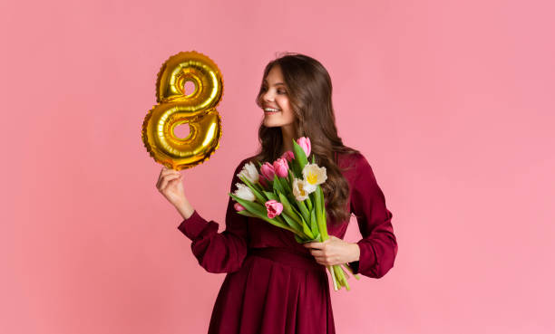 mooie vrouw met 8-vormige ballon en tulpenbloemboeket - womens day stockfoto's en -beelden