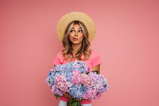 beautiful woman with a bouquet of flowers - hoed stockfoto's en -beelden