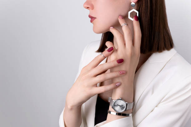 mooie vrouw met een roze manicure in minimale stijl met juwelen - woman horloge stockfoto's en -beelden