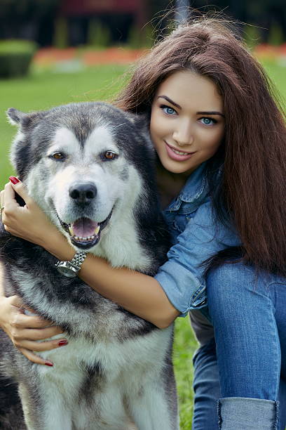 beautiful-woman-with-malamute-dog-picture-id515701421