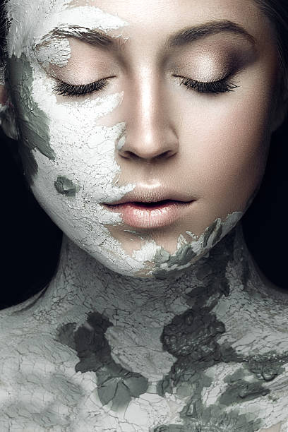 Beautiful woman with silver cosmetic mask covering her face Beautiful girl with mud on his face. Cosmetic mask. Beauty face. Picture taken in the studio on a black background. spa treatment photos stock pictures, royalty-free photos & images