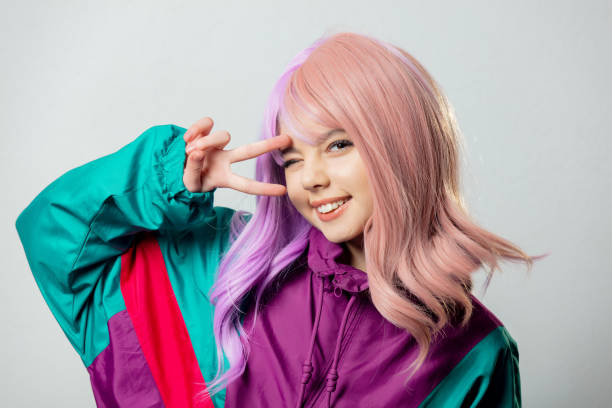Beautiful yandere girl with purple hair and 80s tracksuit on gray background stock photo