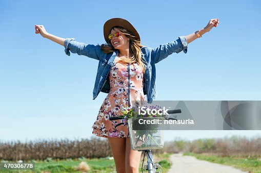 istock A beautiful young female riding a vintage bicycle in a field 470306778