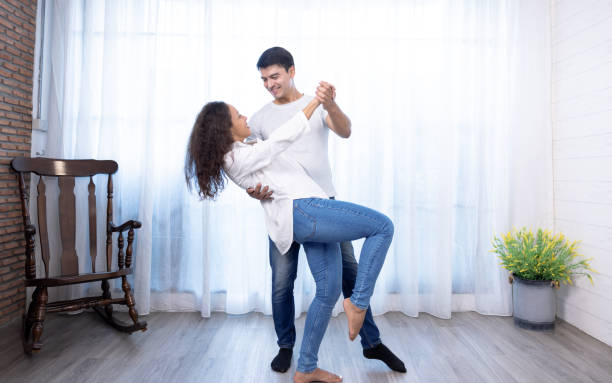 Beautiful young woman and handsome man are enjoying spending time together, Couple is dancing. stock photo