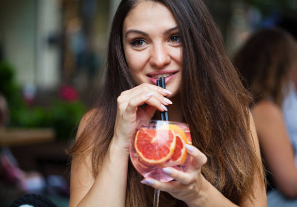 Beautiful young woman drinking a cocktail stock photo