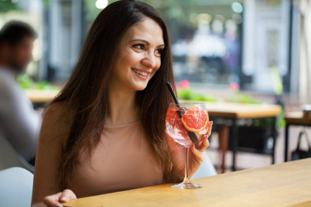 Beautiful young woman drinking a cocktail stock photo