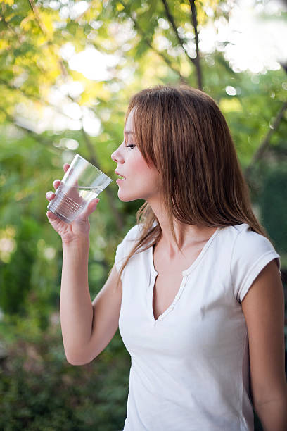 Beautiful young woman drinking water stock photo