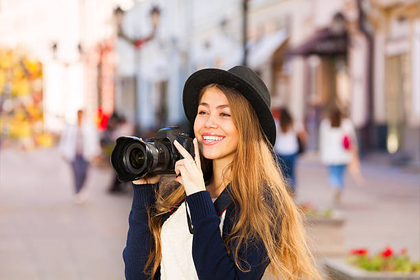 Beautiful young woman in retro outfit shooting with camera touristic...
