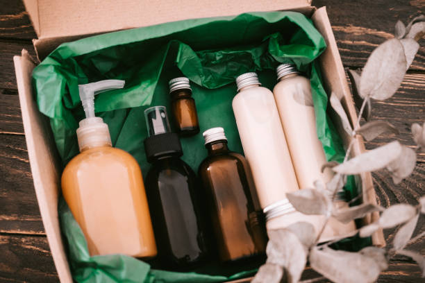 Beauty box with bottles of natural cosmetics Beauty box with bottles of natural cosmetics, wrapped in green paper. Blogger hair and body care routine, salon treatments cosmetic packaging stock pictures, royalty-free photos & images