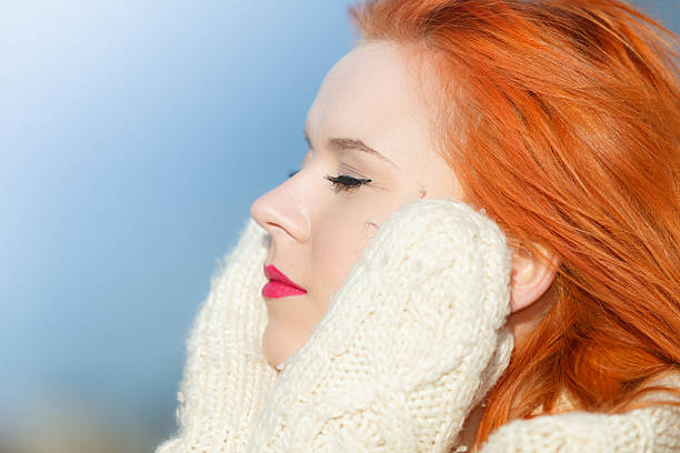 Winter fashion. Beauty face portrait red hair young woman in warm...