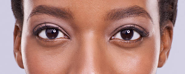 Beauty is in the eyes... Cropped shot of a beautiful african woman against a purple background eye close up stock pictures, royalty-free photos & images