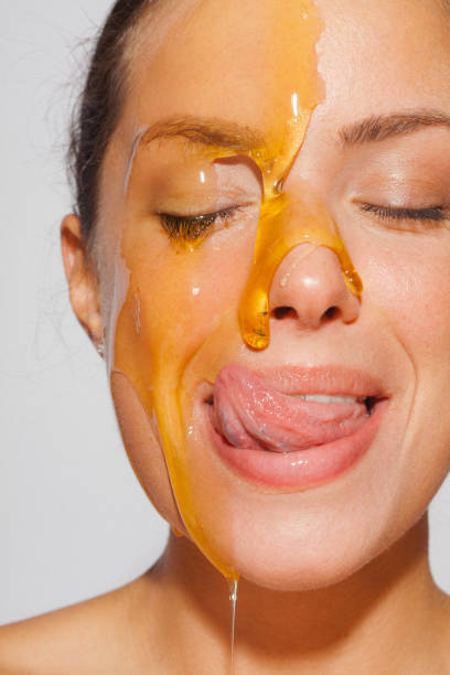 Beauty portrait of a young woman with honey over her face skin stock photo