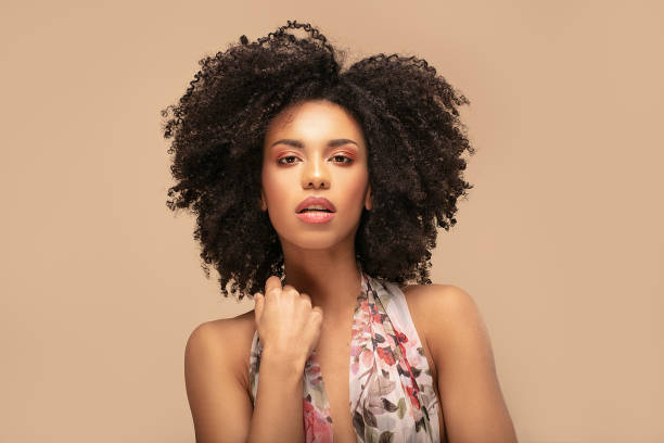 Beauty portrait of afro woman. Beauty portrait of beautiful emotional african american girl with curly hair on beige studio background. curly hair stock pictures, royalty-free photos & images