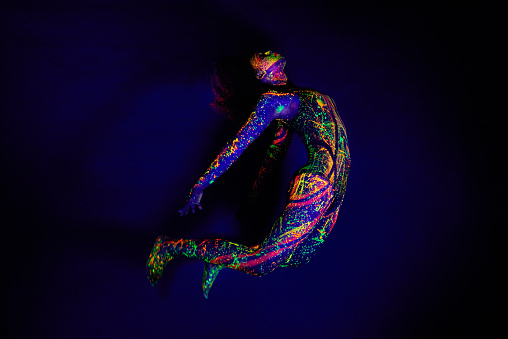 Full length shot of a young woman posing with neon paint on her face