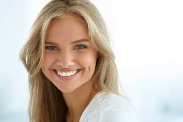 Beauty Woman Portrait. Girl With Beautiful Face Smiling Beauty Woman Portrait. Closeup Of Beautiful Happy Girl With Perfect Smile, White Teeth Smiling At Camera. Attractive Healthy Young Female With Fresh Natural Face Makeup Indoors. High Resolution Image beautiful fresh skin stock pictures, royalty-free photos & images