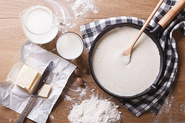 bechamel sauce in a pan and ingredients horizontal top view stock photo