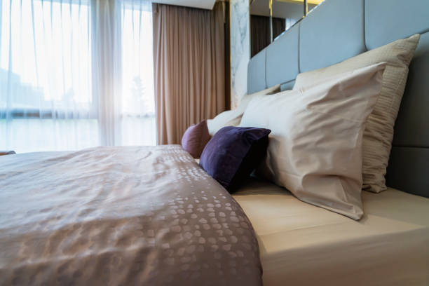 Ropa de cama con almohadas blancas limpias y sábanas en el dormitorio de belleza. De cerca. Fondo interior - foto de stock