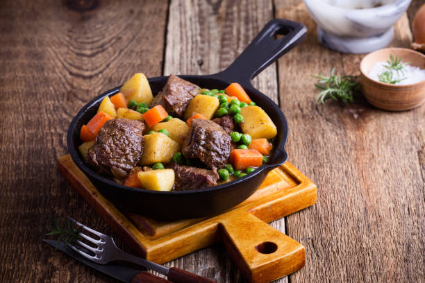 Beef and vegetable stew with potatoes Beef and vegetable stew with potatoes in cast iron skillet on rural table comfort food stock pictures, royalty-free photos & images