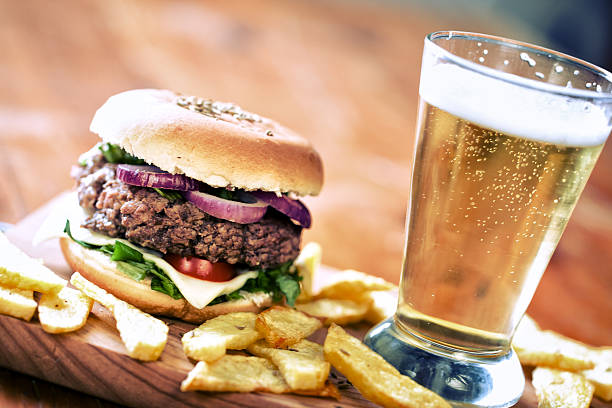 Beef bagel hamburger with potato wedges and fresh beer stock photo