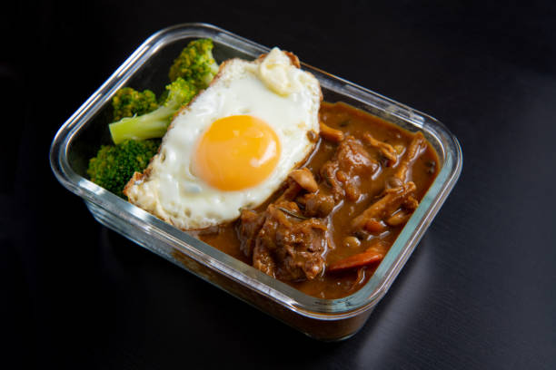 beef Curry Rice on black wooden background ( Onsen tamago, Potato, enoki mushroom, onion, broccoli, Japanese style) stock photo