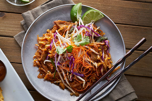 beef pad thai shot from overhead view beef pad thai shot from overhead view on wooden table in flat lay composition. asian food stock pictures, royalty-free photos & images