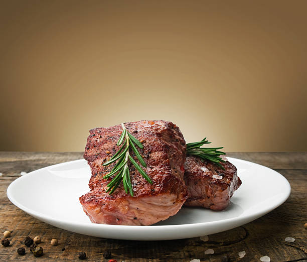 beef steak on a wooden table - barbecue maaltijd stockfoto's en -beelden