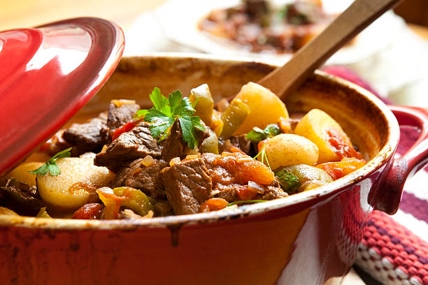 Beef Stew Traditional goulash or beef stew, in red crock pot, ready to serve.  Shallow DOF.  More beef images: casserole stock pictures, royalty-free photos & images