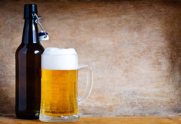 Mug and bottle of beer with text copy space on a wooden background
