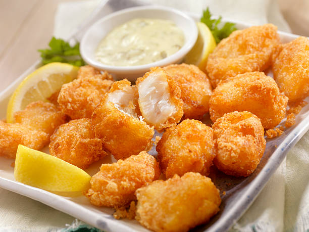 Beer Battered Fish Bites with Tarter Sauce Beer Battered Fish Bites with Tarter Sauce and a Beer  - Photographed on Hasselblad H3D2-39mb Camera fish fry stock pictures, royalty-free photos & images