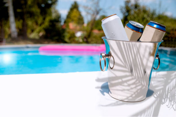 Beer cans cooling by the pool stock photo