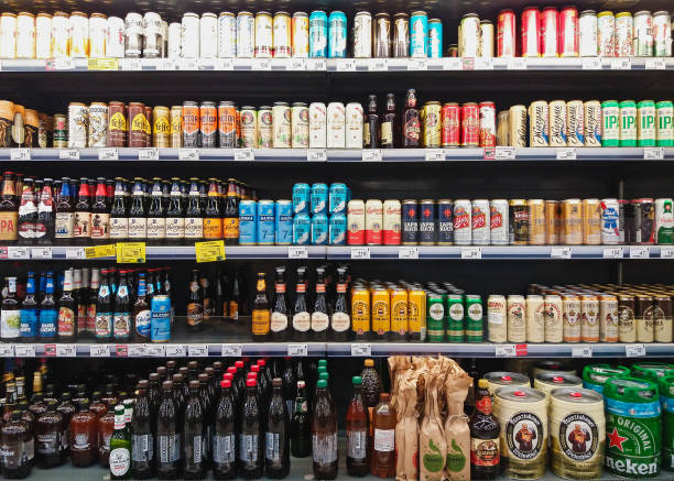 Beer in bottles and cans on grocery store shelves stock photo