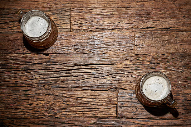 cerveza para tazas  - mano agarrando botella de cerveza y taza fotografías e imágenes de stock