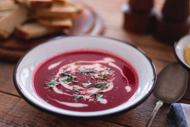 Beetroot soup with bread pieces at table, close-up stock photo