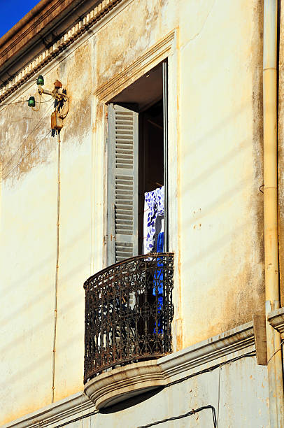Bejaia, Algeria: balcony Bejaia, Algeria: narrow wrought iron balcony of a colonial building - wall with a downspout - photo by M.Torres kabylie stock pictures, royalty-free photos & images