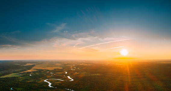 Belarus. Aerial View. Beautiful Sunset Sun Sunshine Above Summer Green Forest And River Landscape In Sunny Evening. Top View Of European Nature From High Attitude In Summer Sunrise. Bird's Eye View.