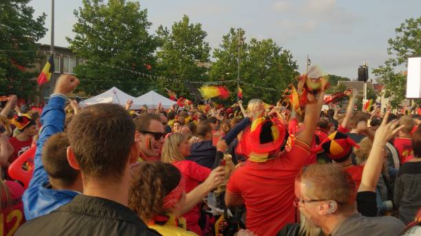 Belgian football fans celebrating a scored goal during a match Kapellen, Belgium, June 2018, Belgian football fans celebrating a scored goal during a match. Supporters seeing the match on a big screen on the city square. belgian culture stock pictures, royalty-free photos & images