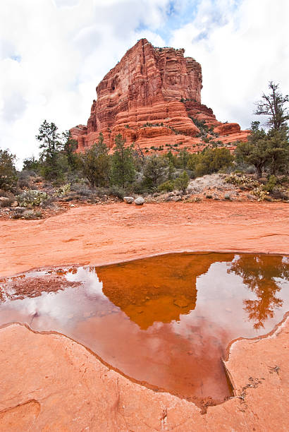Courthouse Butte Reflected in a Wash Bell Rock and Courthouse Butte are two prominent and beautiful sandstone peaks at the south edge of the red rock formations of the Coconino National Forest near Sedona, Arizona, USA. jeff goulden sedona stock pictures, royalty-free photos & images