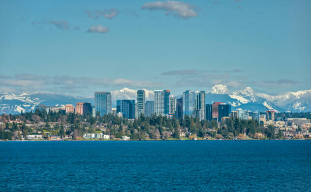 Bellevue, Washington and Cascade Mountains over Lake Washington The Snow Capped Cascade Mountain Range stand Tall Behind the City of Bellevue, Washington and Lake Washington on a Sunny and Blue Afternoon cascade range stock pictures, royalty-free photos & images