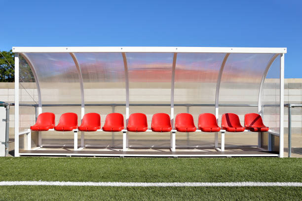 bench with red plastic seats for players at the stadium sport bench with red plastic seats in the stadium players outdoors with red paint under transparent plastic roof as banking players bench stock pictures, royalty-free photos & images