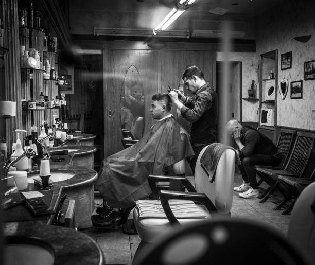 Berber works at small barber shop in Milan, Italy Milan, Italy - March 23, 2016:  Berber works at small barber shop in Milan, Italy vintage beauty salon stock pictures, royalty-free photos & images