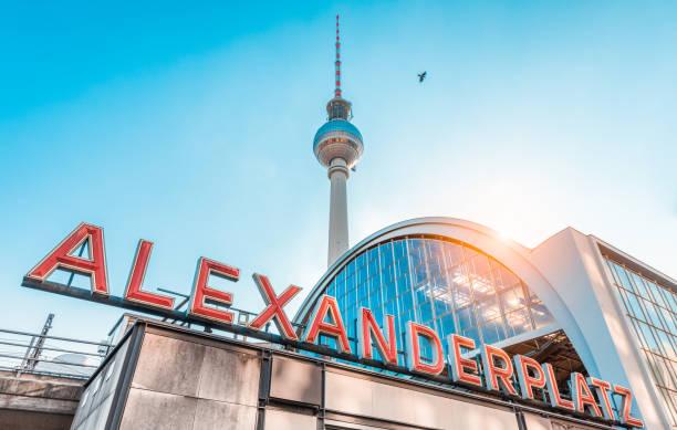 Berlin Alexanderplatz with TV tower at sunset, Germany Wide-angle view of Alexanderplatz neon sign with famous TV tower and train station in golden evening light at sunset in summer, central Berlin Mitte district, Germany central berlin stock pictures, royalty-free photos & images