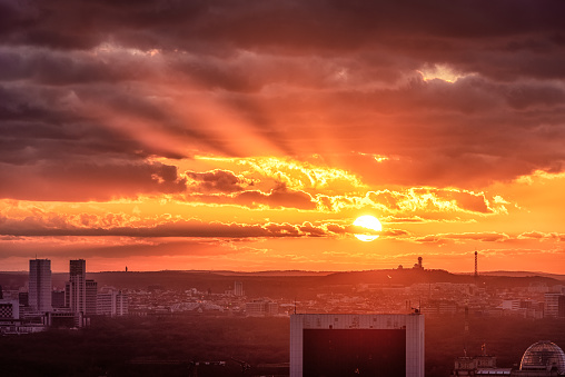 Berlin skyline at sunset, with a big yellow sun behind the clouds, Germany
